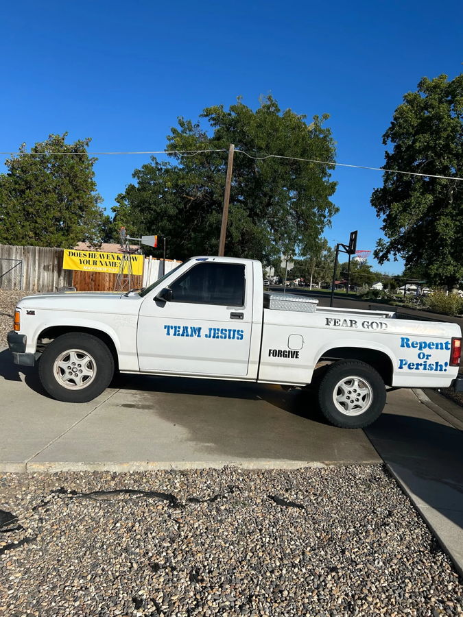 Side profile of Miranda's 1994 Dodge Dakota white regular cab pickup with Team Jesus Forgive Fear God and Repent Or Perish decals photo 1