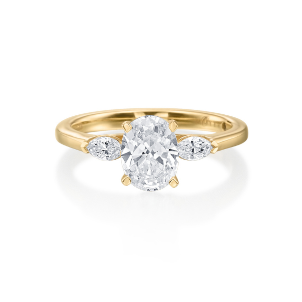 Gold ring featuring an oval diamond center stone and side stones.