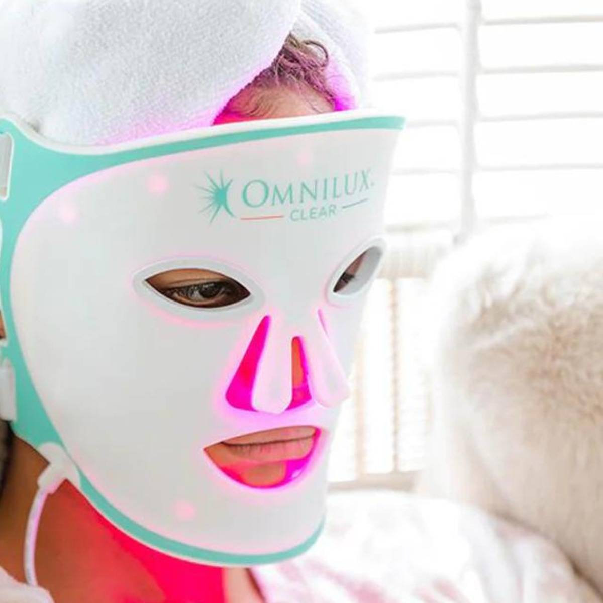 Woman wearing Omnilux Clear Mask at home