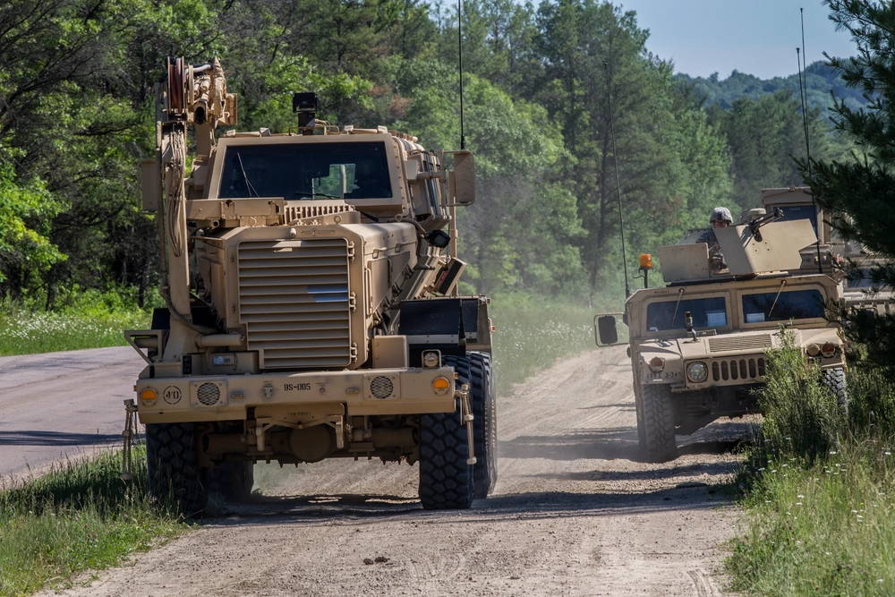 The Buffalo mine resistant ambush vehicle rolls ahead to a suspected IED as Soldiers with 2nd Platoon, 323rd Engineering Clearance Company, sit in an overwatch position on a route clearance mission while at the Combat Support Training Exercise at Fort McCoy, Wis., June 19, 2015. Soldiers with 2nd Platoon use the Husky vehicle mounted mine detector, Buffalo mine resistant ambush protected vehicle, and Talon tracked military robot to ensure routes are clear of all improvised explosive devices for future vehicles. (U.S. Army photo by Sgt. 1st Class Brian Hamilton)