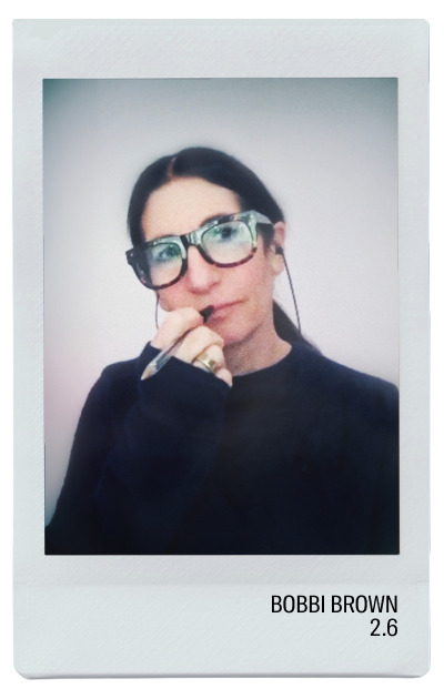 Person wearing glasses, holding a pen, in a casual pose.