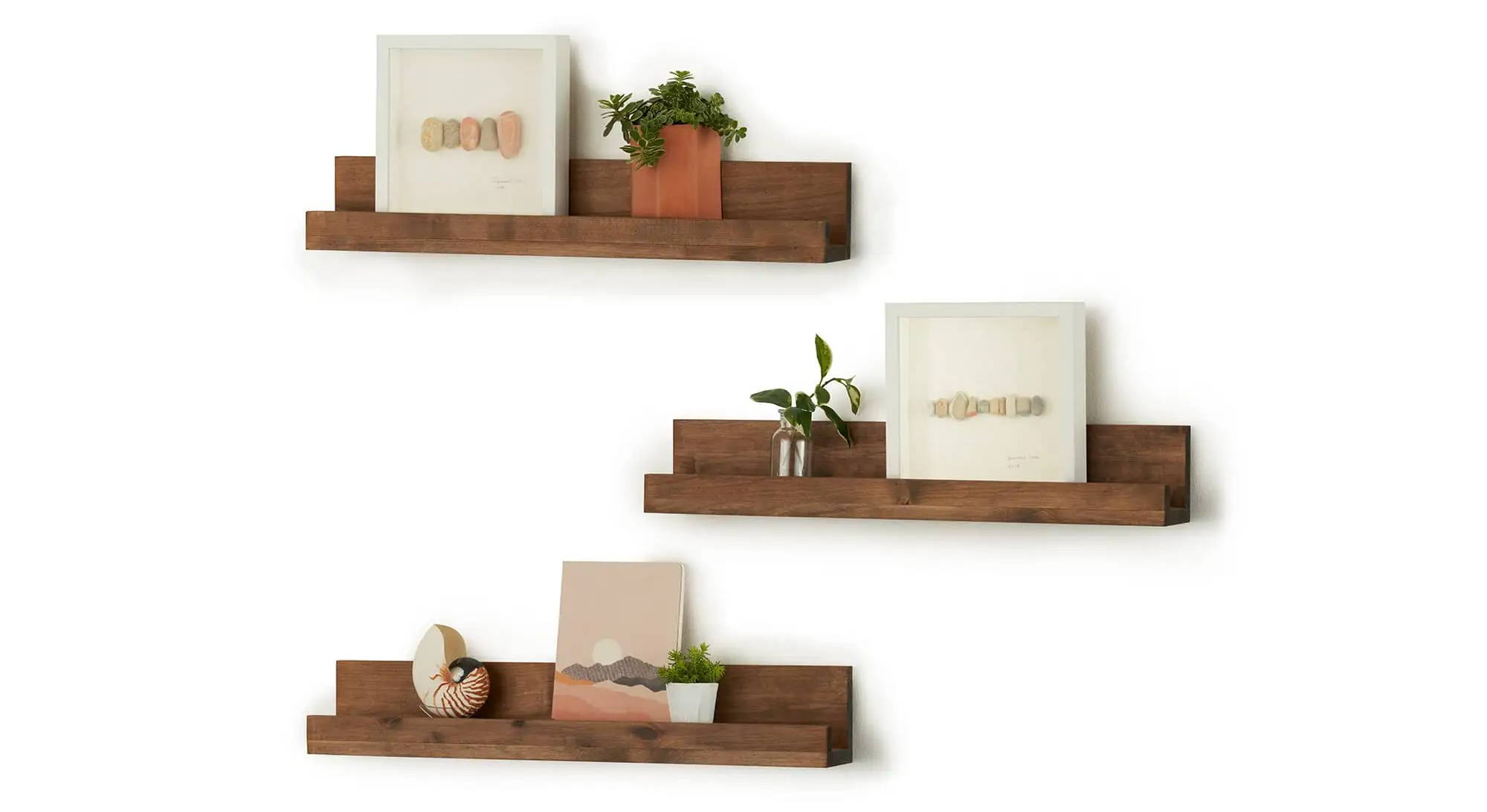 3 floating wall shelves filled with framed art and small planters