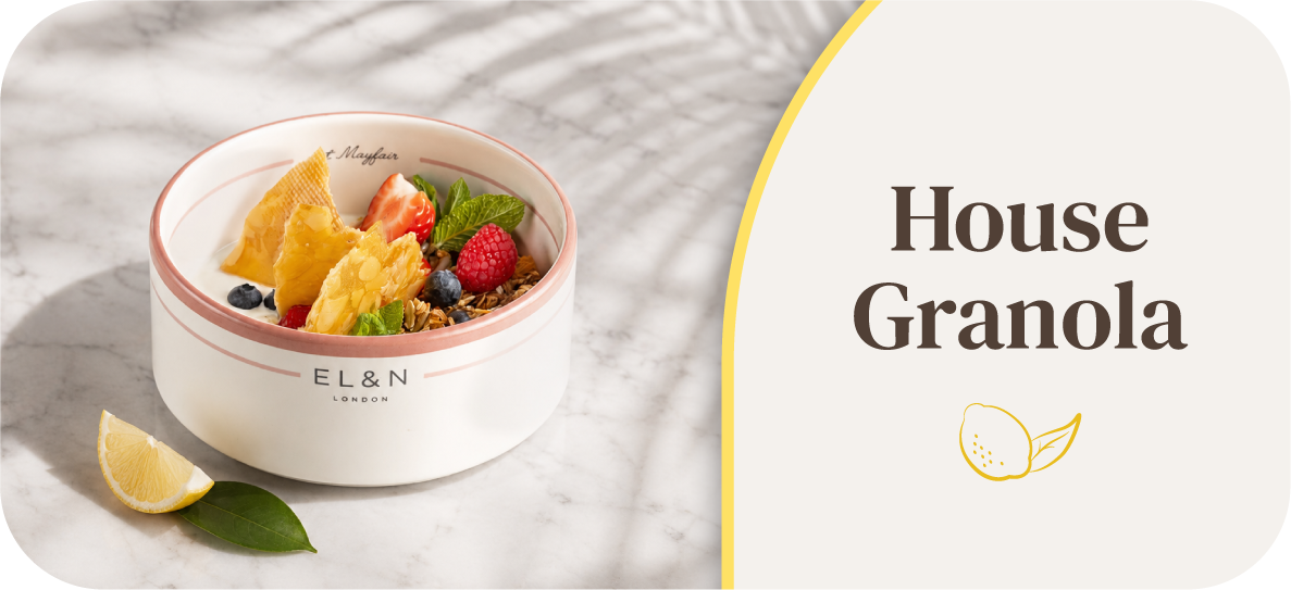 Bowl of granola topped with fruits and a lemon slice.