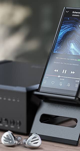 A hi-res audio player on a stand next to a music player and earphones.