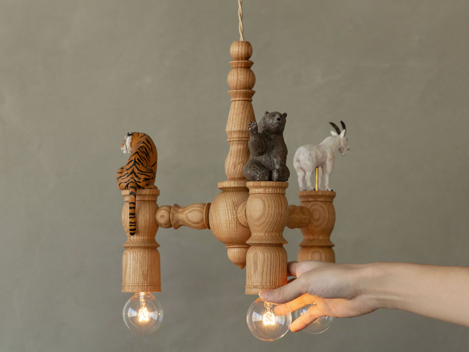 A wooden chandelier featuring animal figurines and light bulbs.