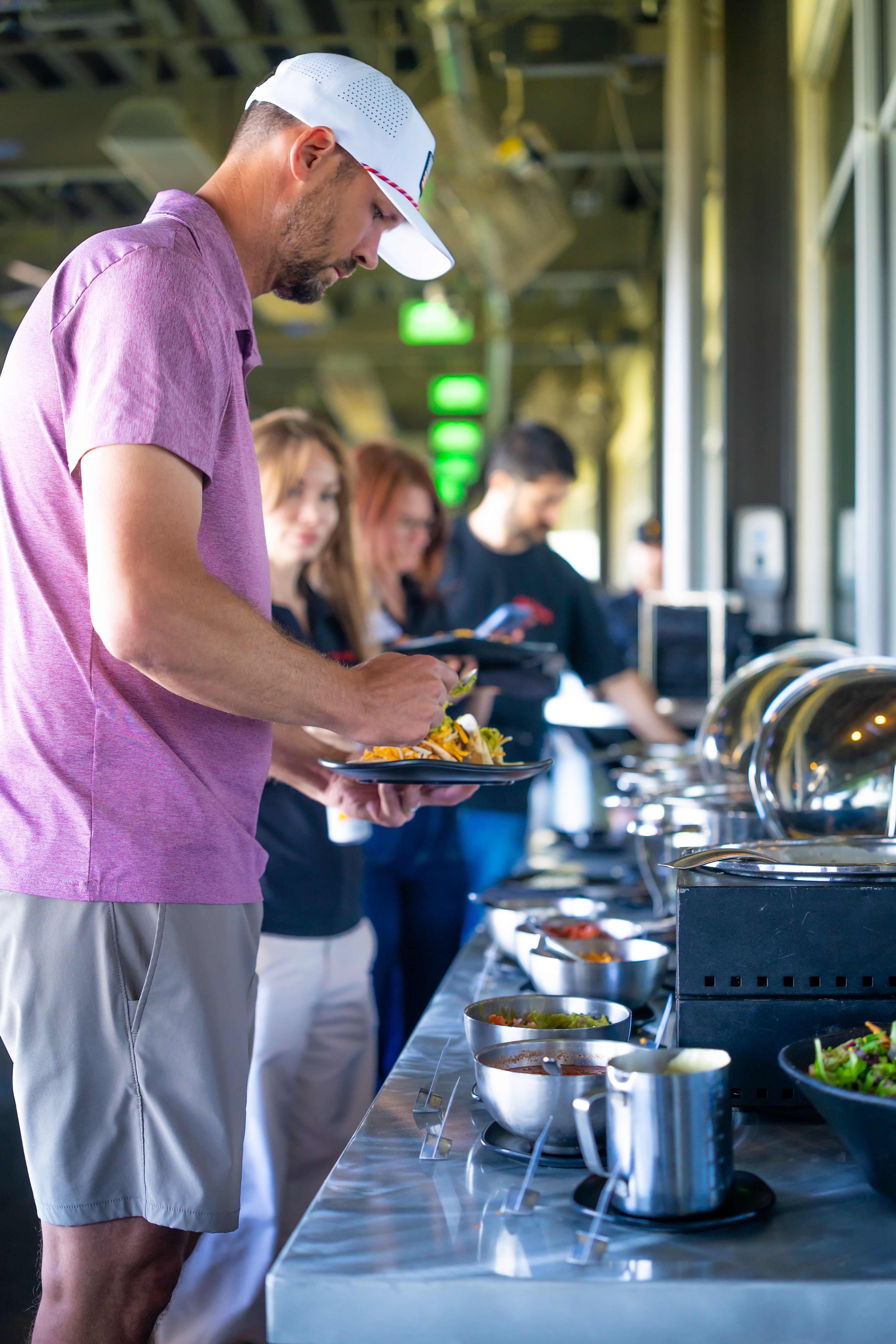 People serving themselves food at a buffet.