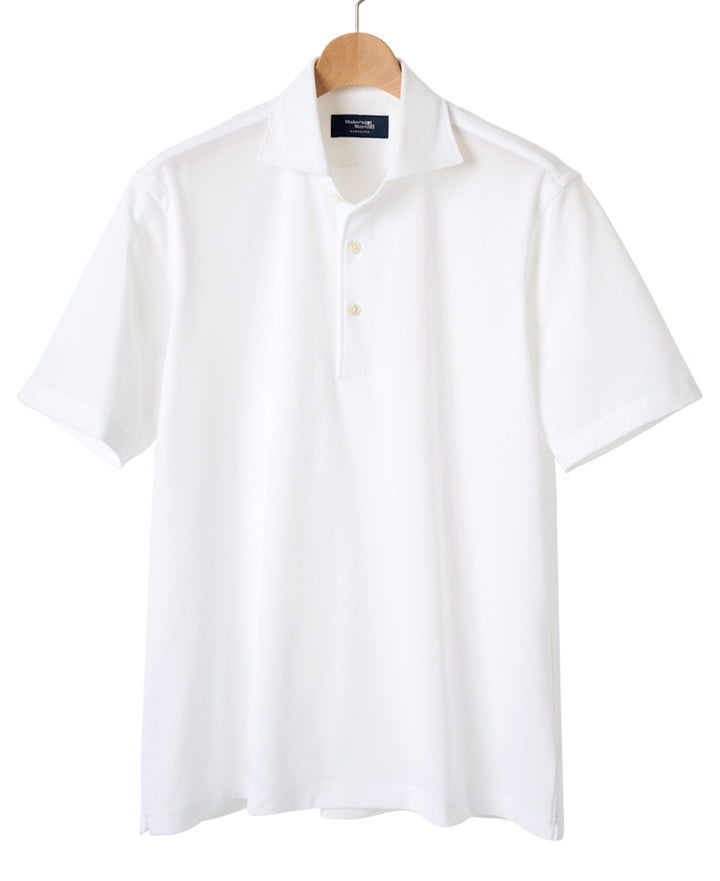White short-sleeve polo shirt hanging on a wooden hanger.