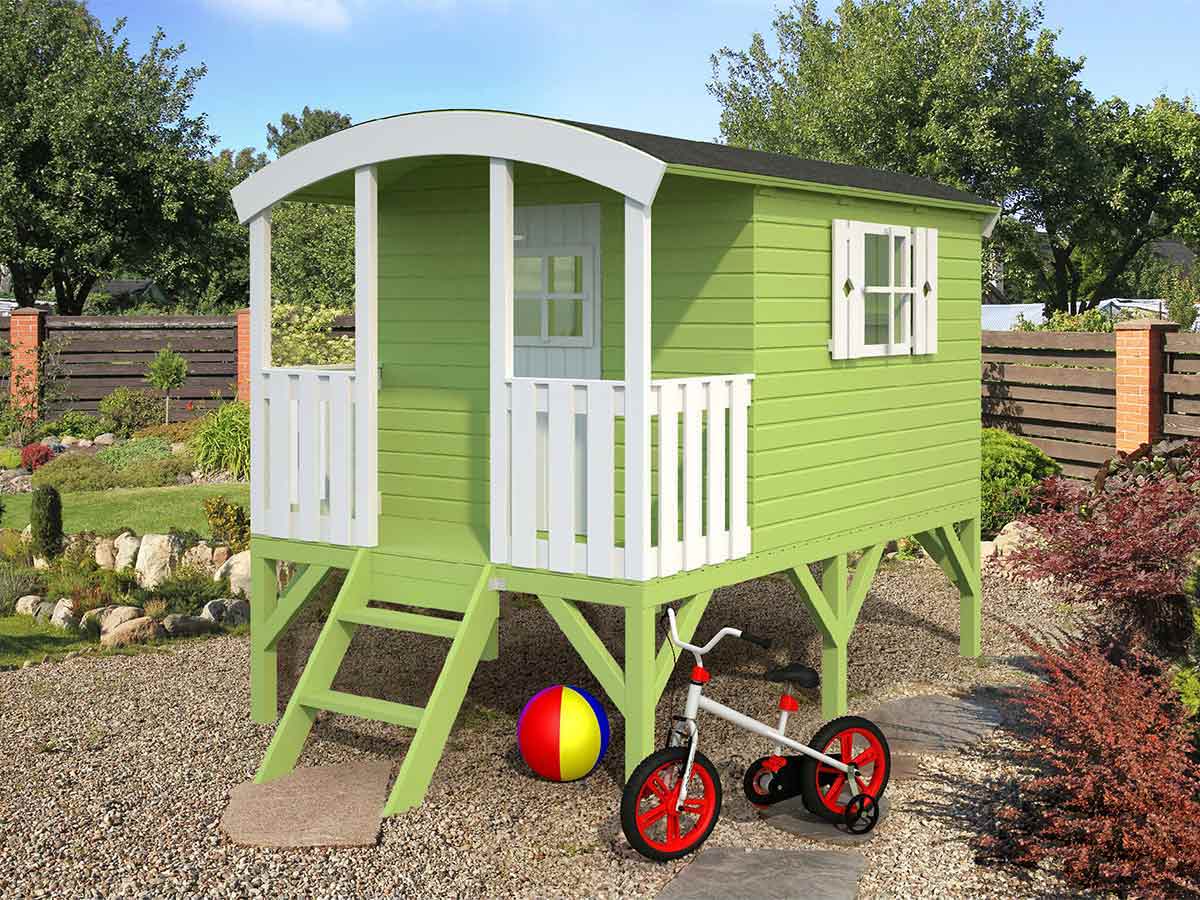  Green Wooden Playhouse DIY Kit Little Bungalow on stilts in the backyard with a bike next to it by WholeWoodPlayhouses