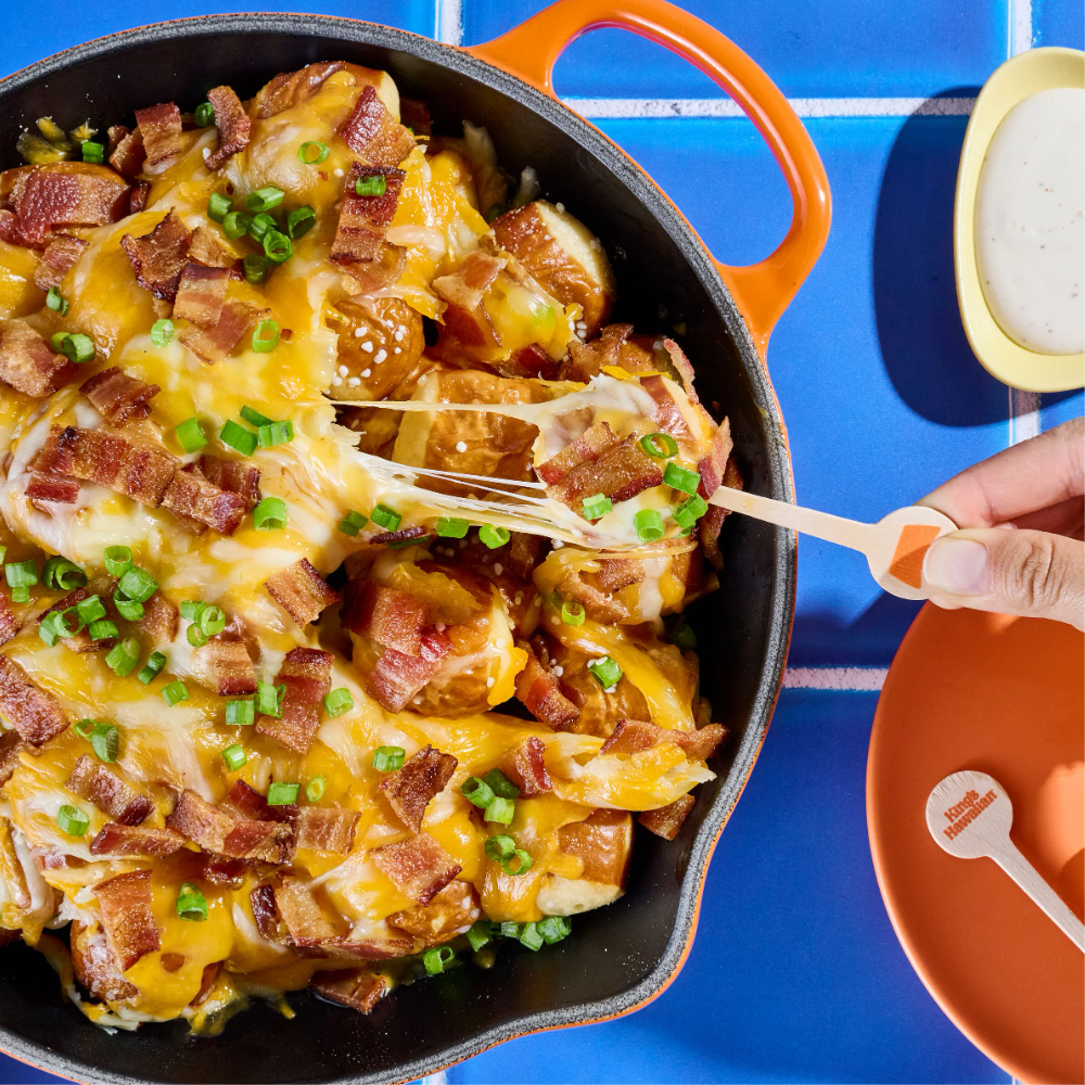 A cheesy potato dish topped with bacon and green onions.