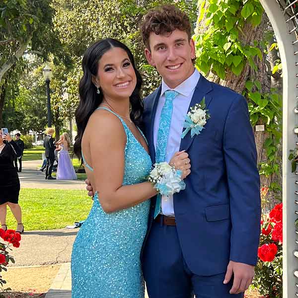 Couple posing for prom in a match turquoise dress and paisley tie