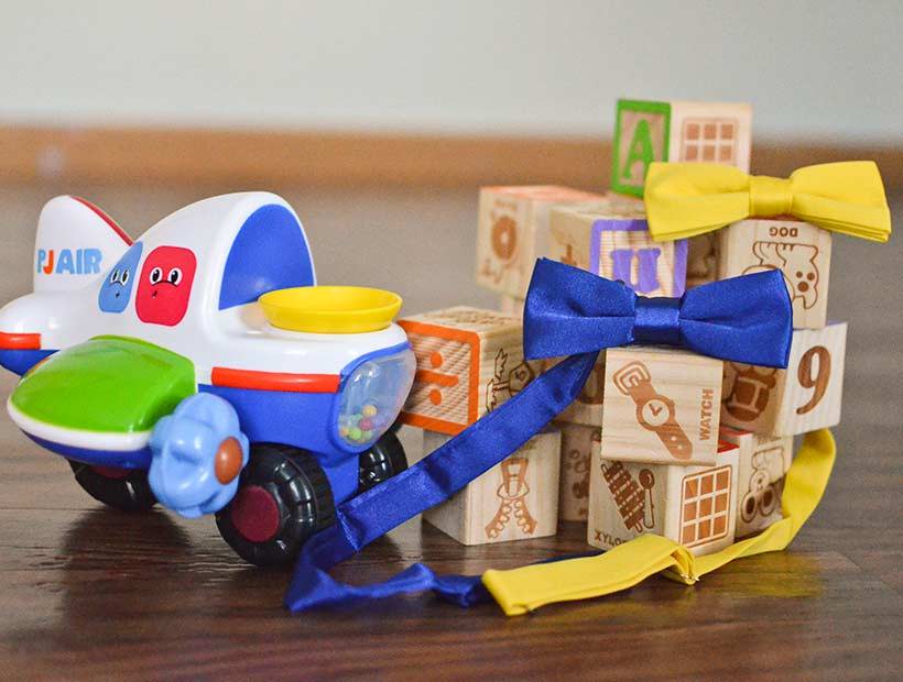 Boys' blue and yellow bow ties displayed among children's assorted toys