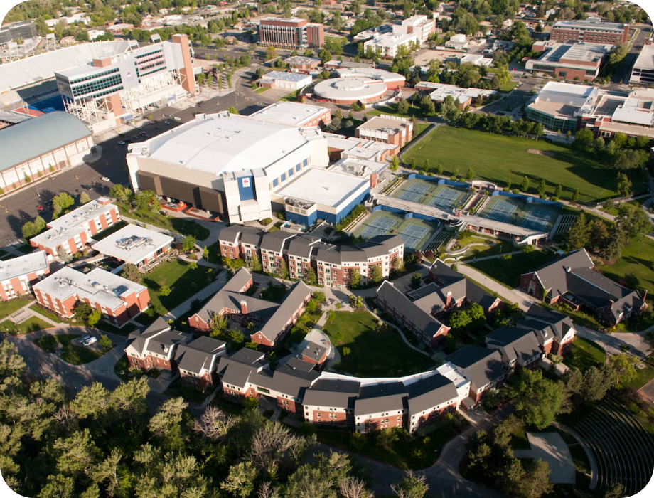 Aerial view of a campus with buildings and green spaces.