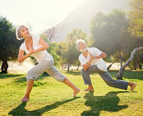 Una foto di una coppia di anziani che fa yoga