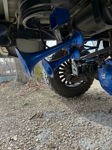 Close-up low-angle view of blue train horns mounted under truck with blue coil spring and ghost differential cover