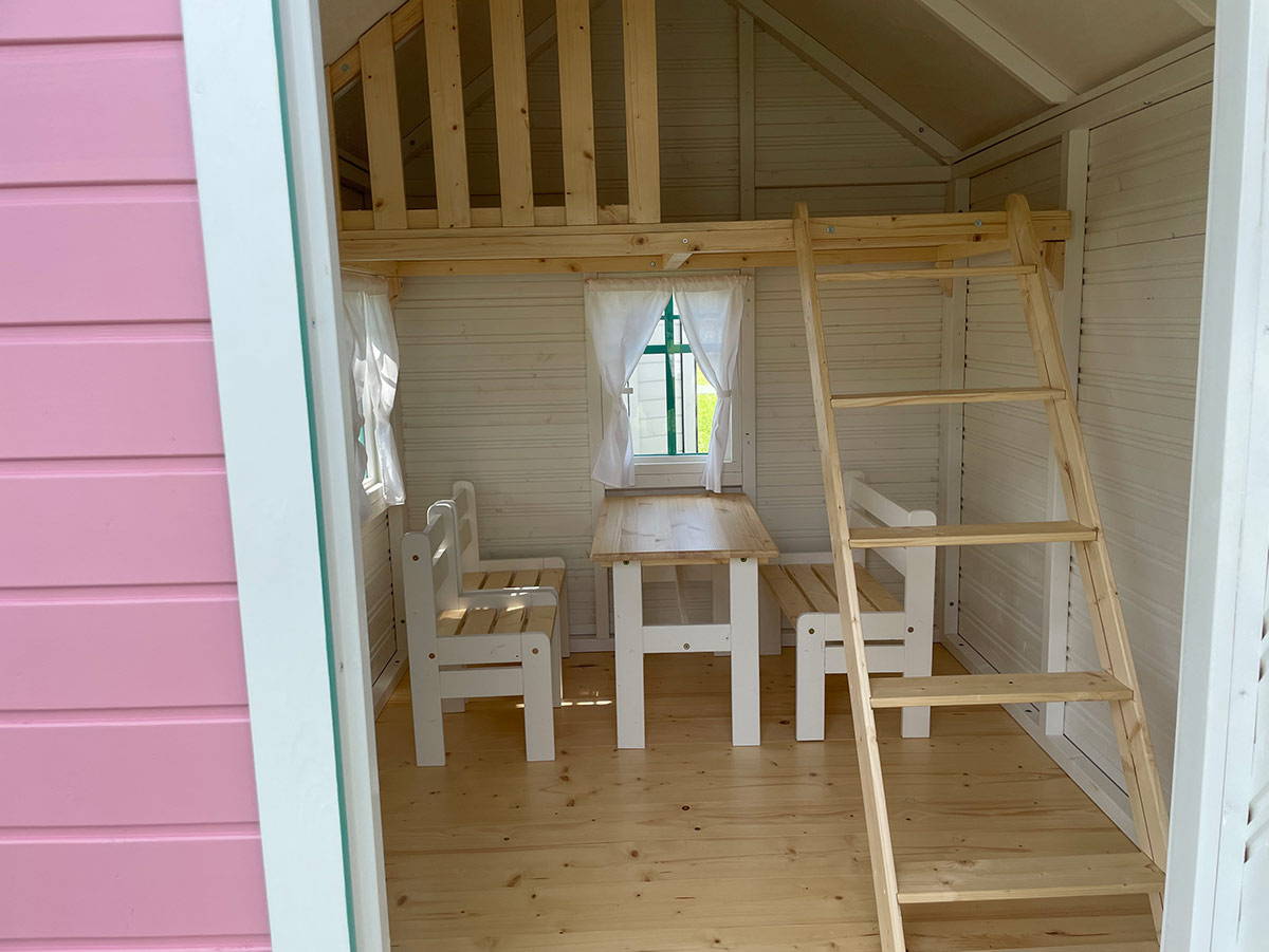 Inside view of Pink Wooden Outdoor Playhouse Unicorn with kids furniture and loft by WholeWoodPlayhouses