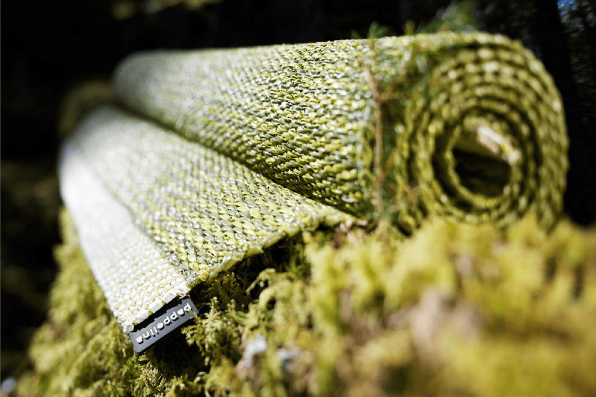 Close-up of a woven green outdoor rug made from food-grade plastic, showing the durable performance material and detailed texture designed for long-lasting outdoor use.