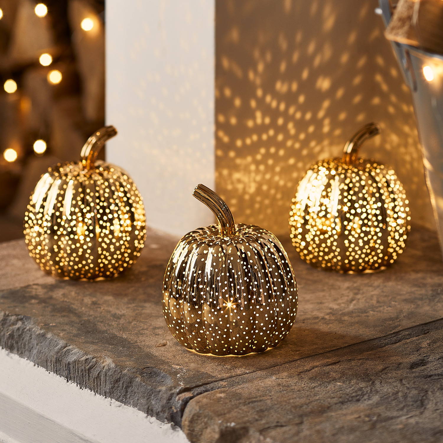 Trio of gold mottled pumpkin LED lights illuminated a fireplace