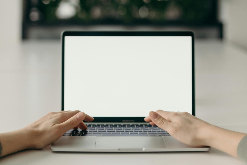 hands working on a bright laptop screen 