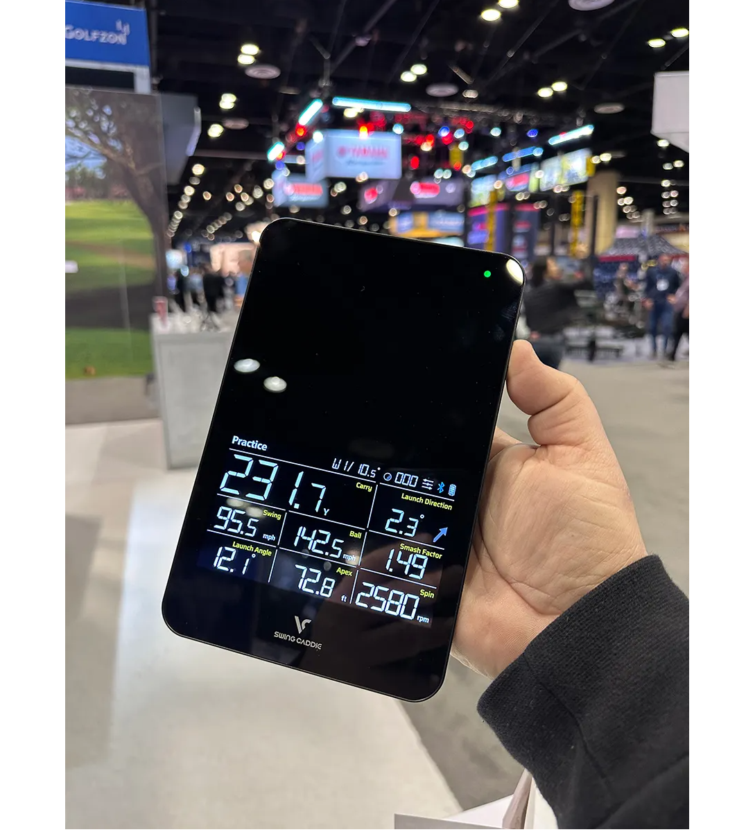 A hand holding the new Swing Caddie SC4 at the 2023 PGA Show