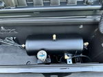 Close-up of black air tank with HornBlasters pressure gauge installed in storage box