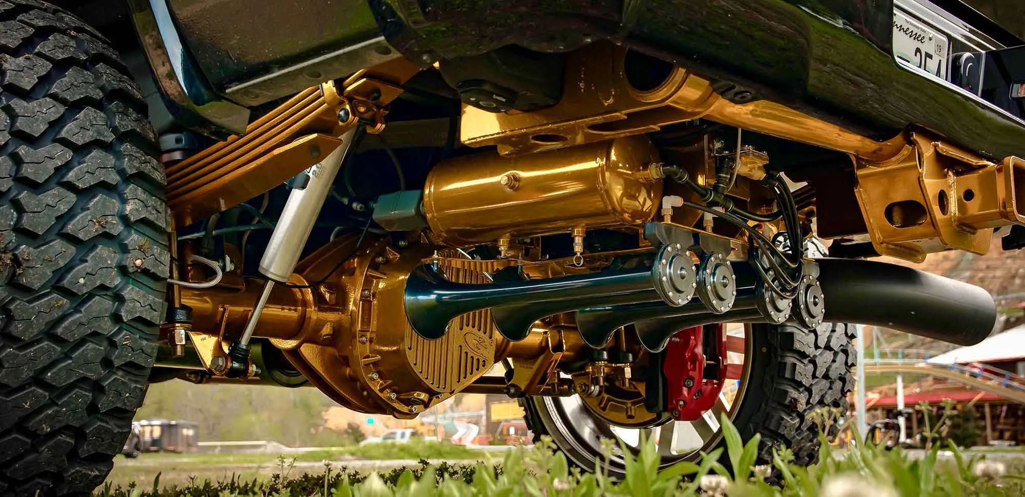 Train horns and gold-painted suspension under a custom truck