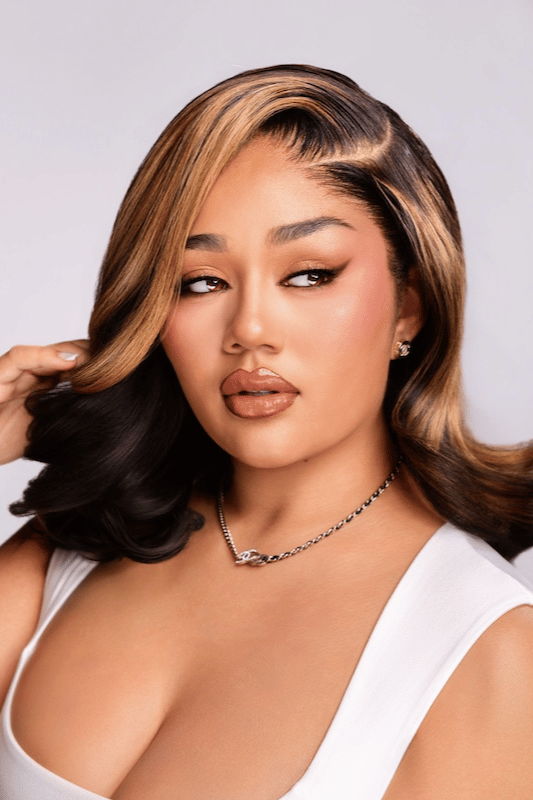 A woman with stylish hair and makeup poses for the camera.