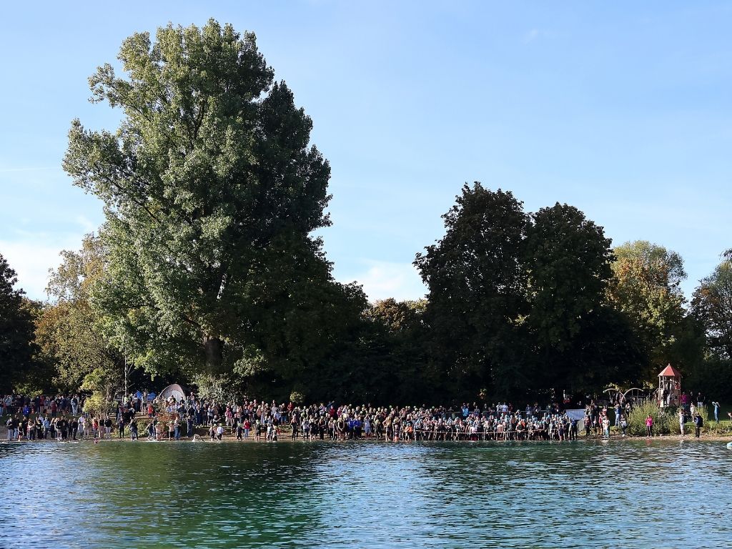Schwimmer und Zuschauer am Ufer vor dem Schwimmstart.