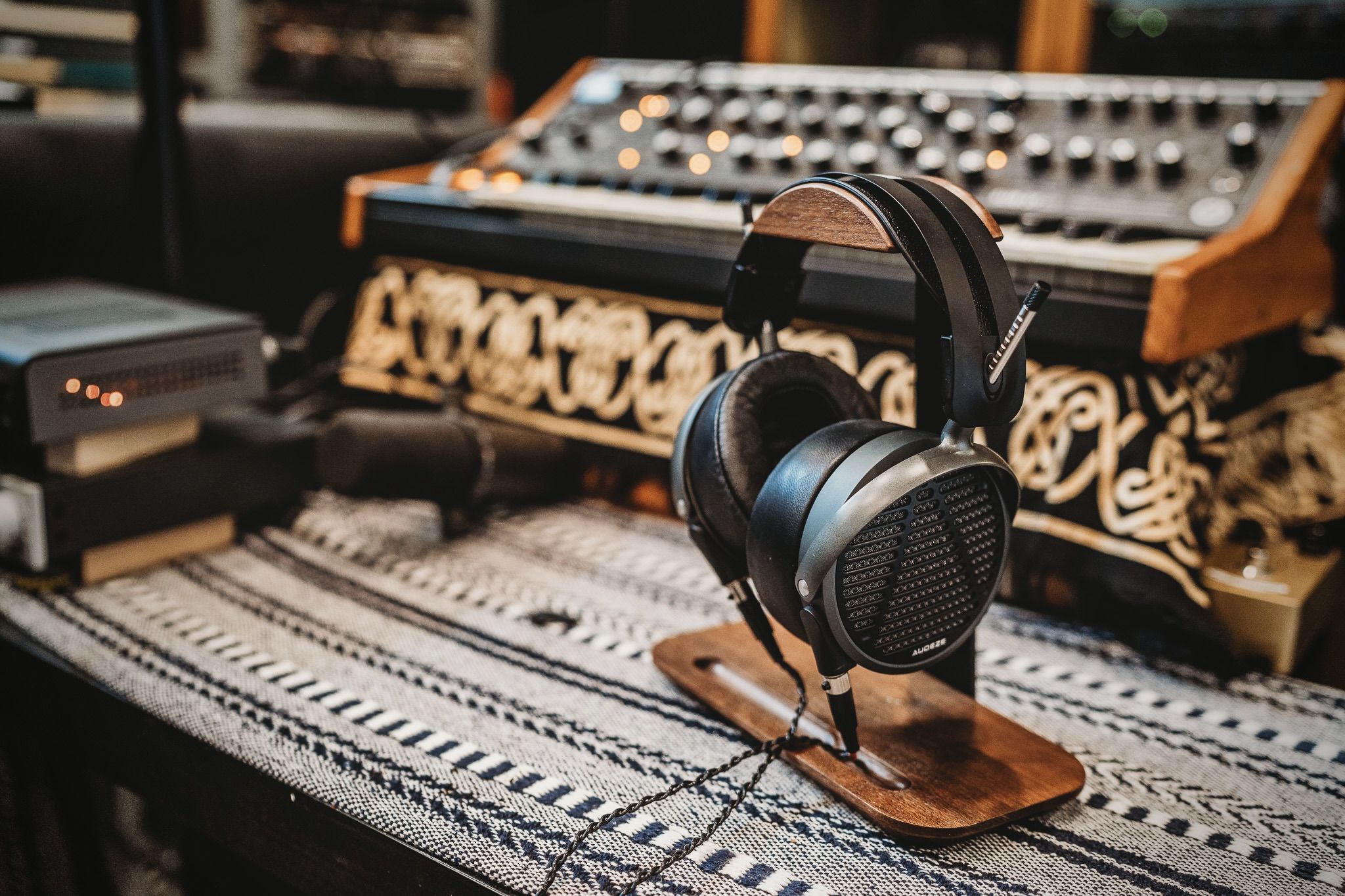 Audeze MM-500 headphones on table in the studio with a keyboard and microphone behind it 