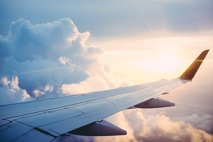 A sunset view from a plane window looking over the plane wing.