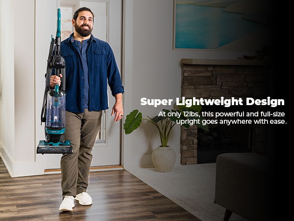 Man holding a lightweight vacuum cleaner in a modern interior setting.