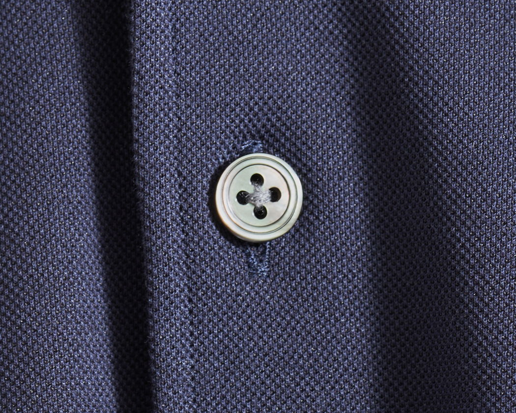 Close-up of a button on a navy fabric.