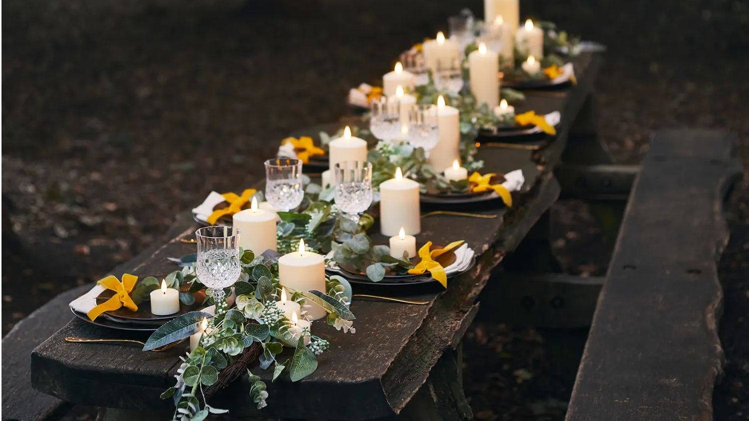 Wedding table with assortment of TruGlow candles and garland styled as part of centrepiece