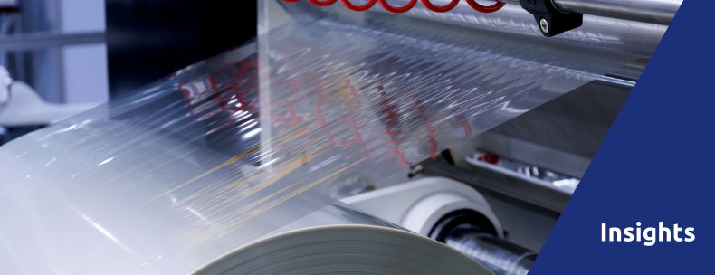 Conveyor belt with plastic film in a manufacturing setting, labeled 