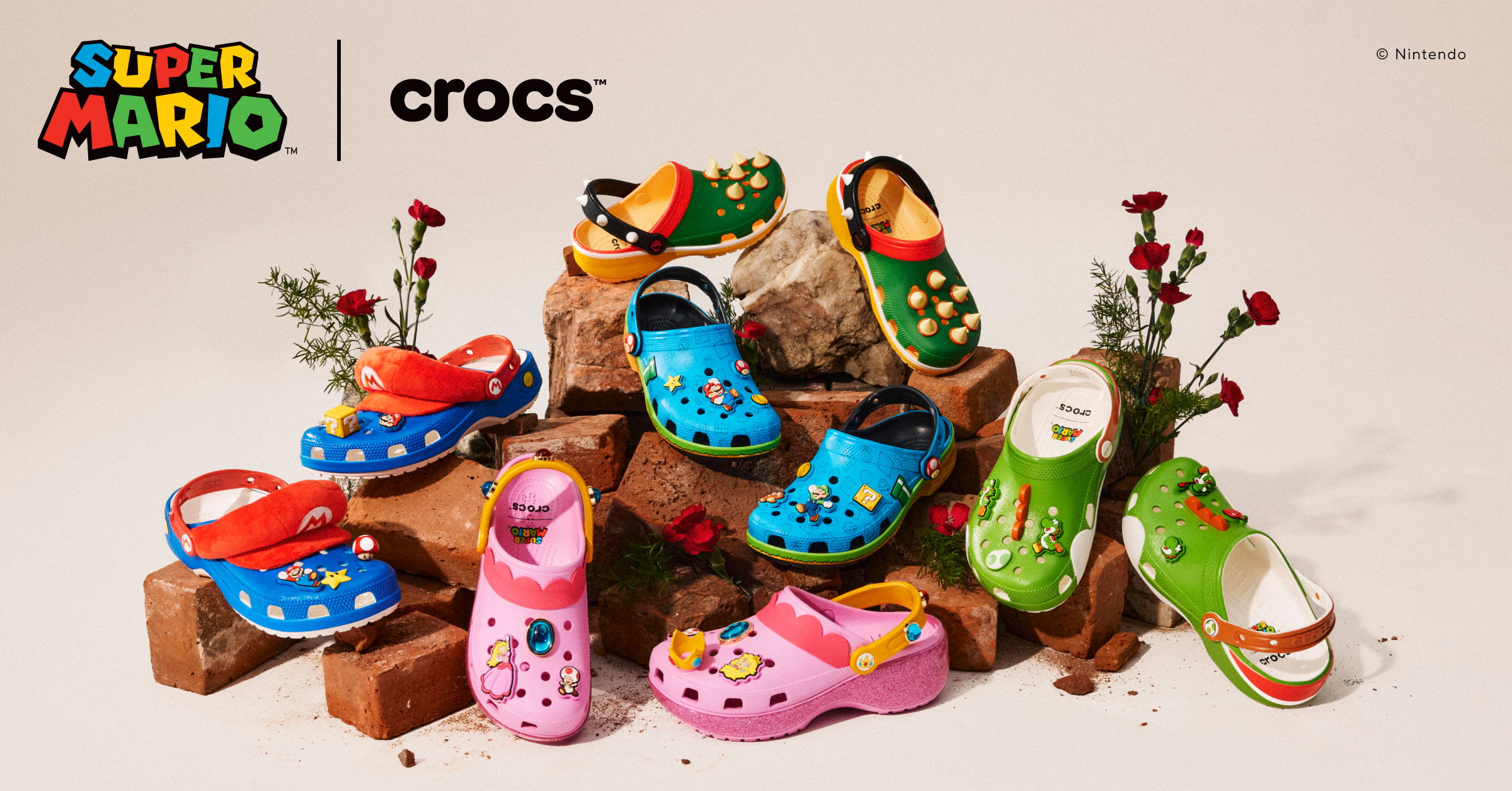 Colorful Super Mario-themed Crocs displayed with flowers and a playful backdrop.