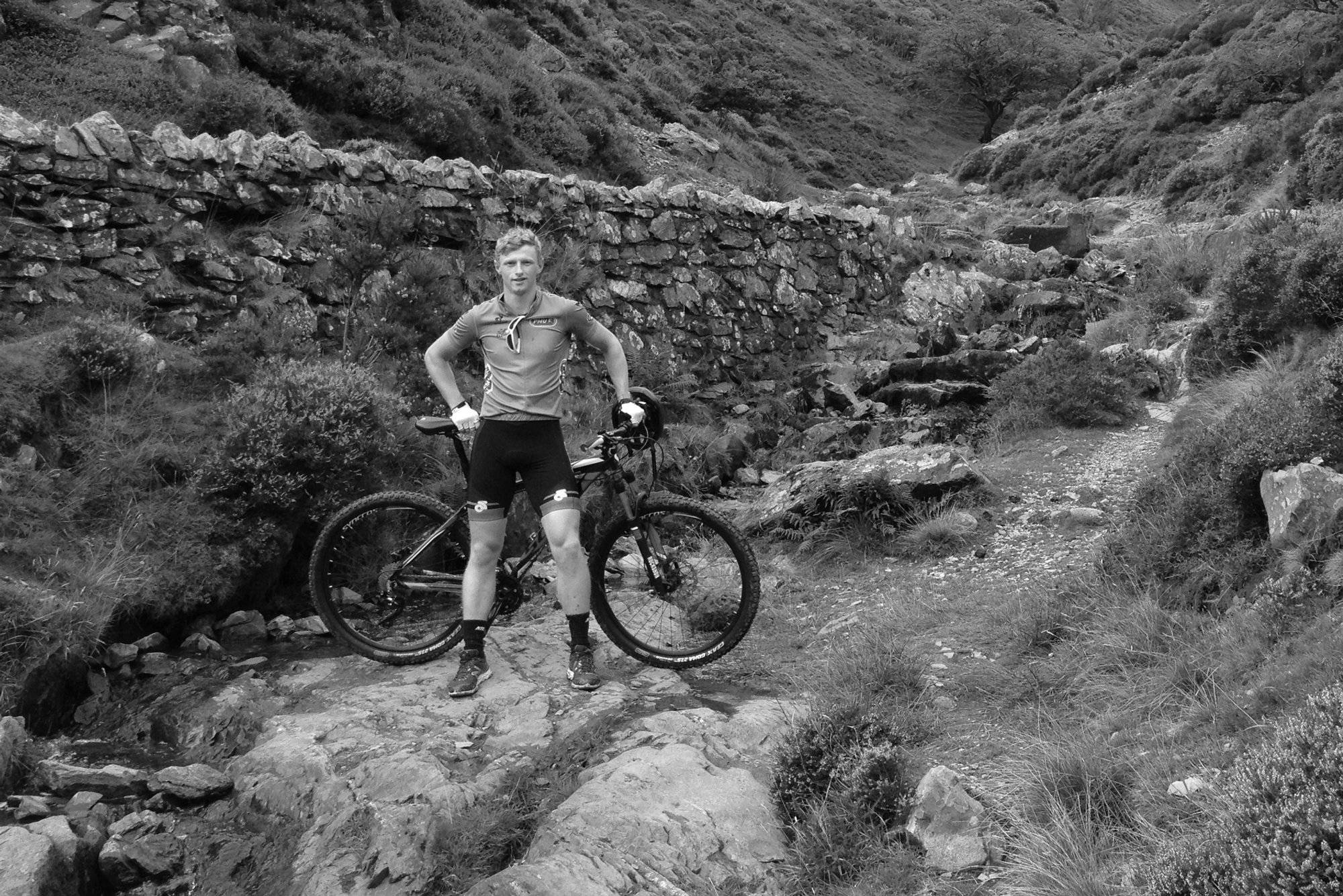 Hunt Development Engineer, Chris, standing next to his bike in the mounatins