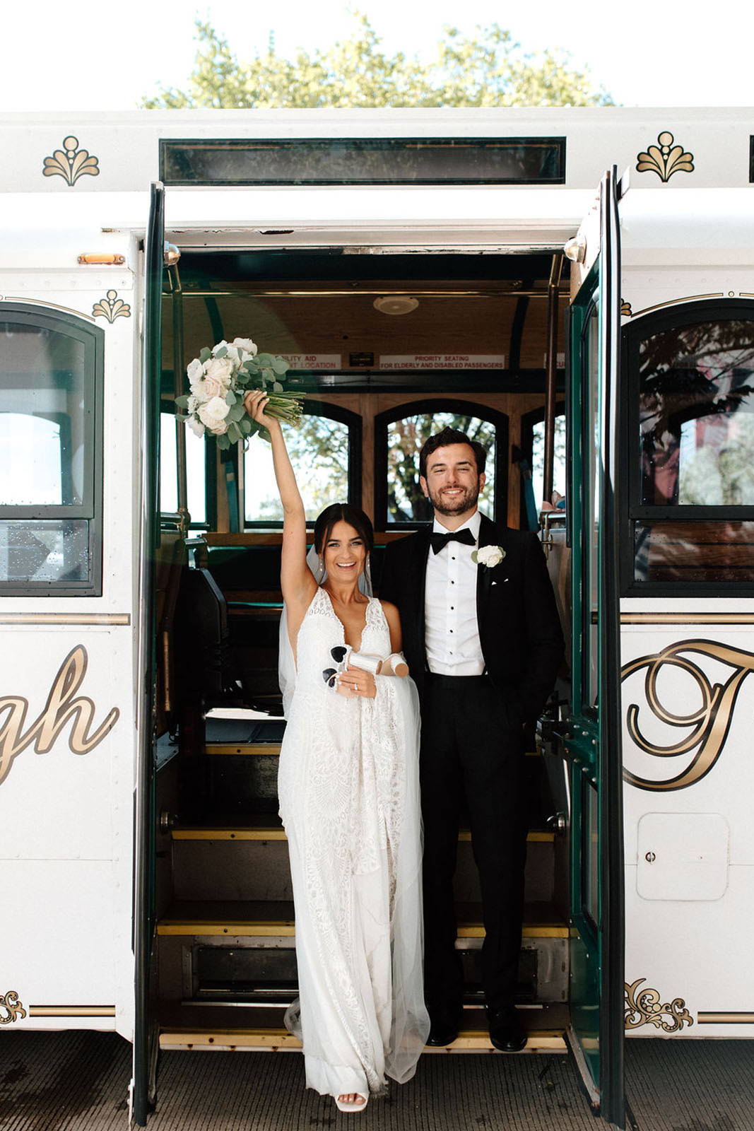 Bride and groom standing on wedding bus