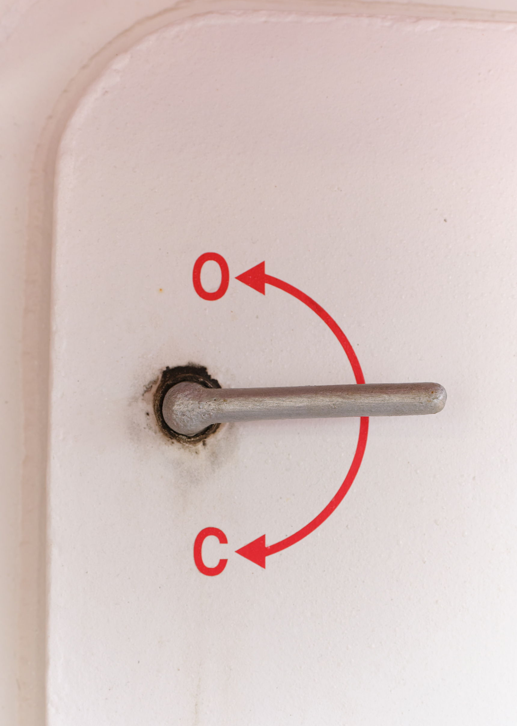 A metal rod with arrows indicating rotation directions on a white surface.