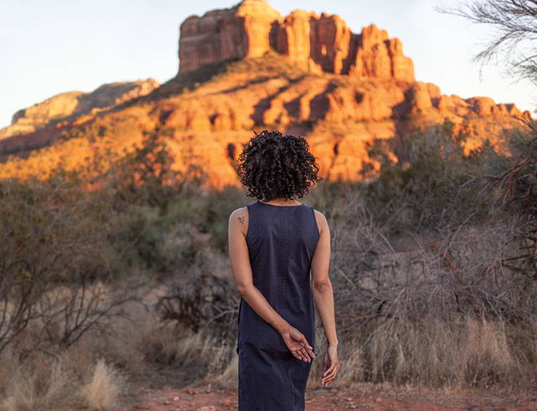 Woman standing in desert wearing navy Nevis dress.