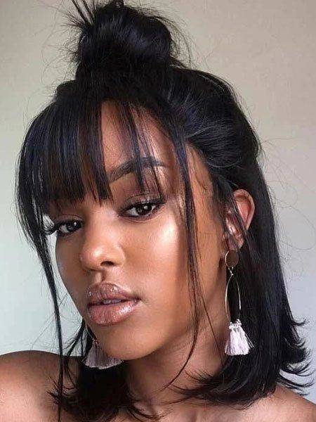 A top knot hairstyle with split bangs