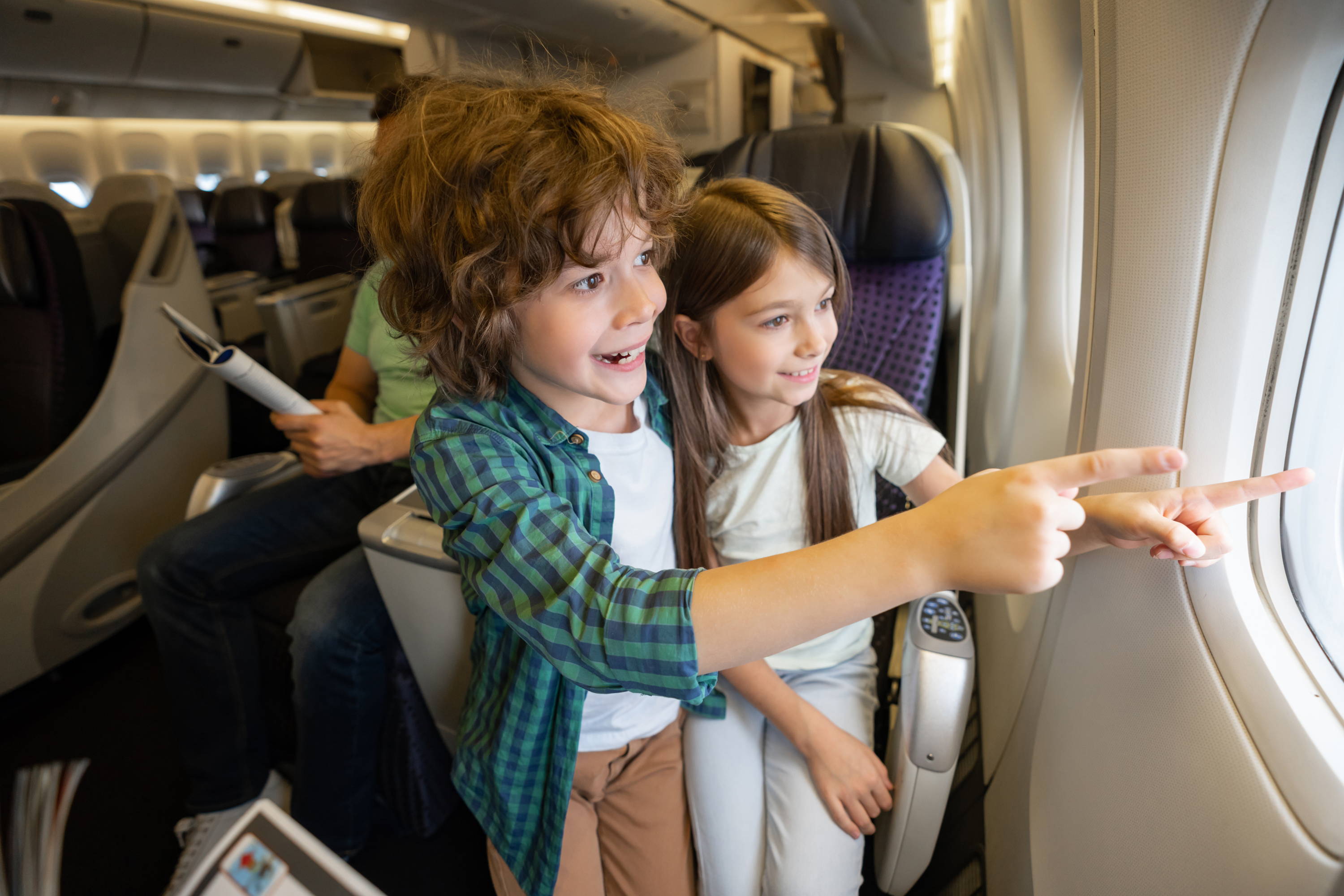 kids looking out window in a plane