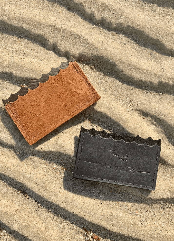 black card holder on sand