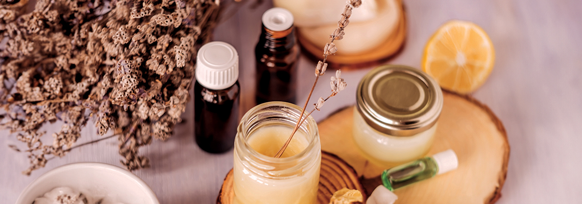 Essential oils and natural ingredients arranged on a wooden surface.