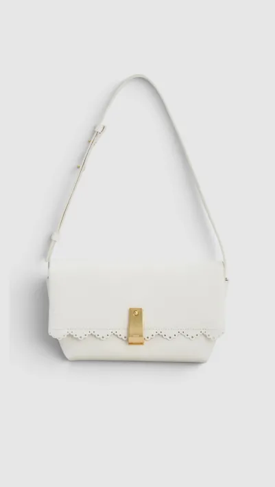 White handbag with gold clasp and decorative embellishments.