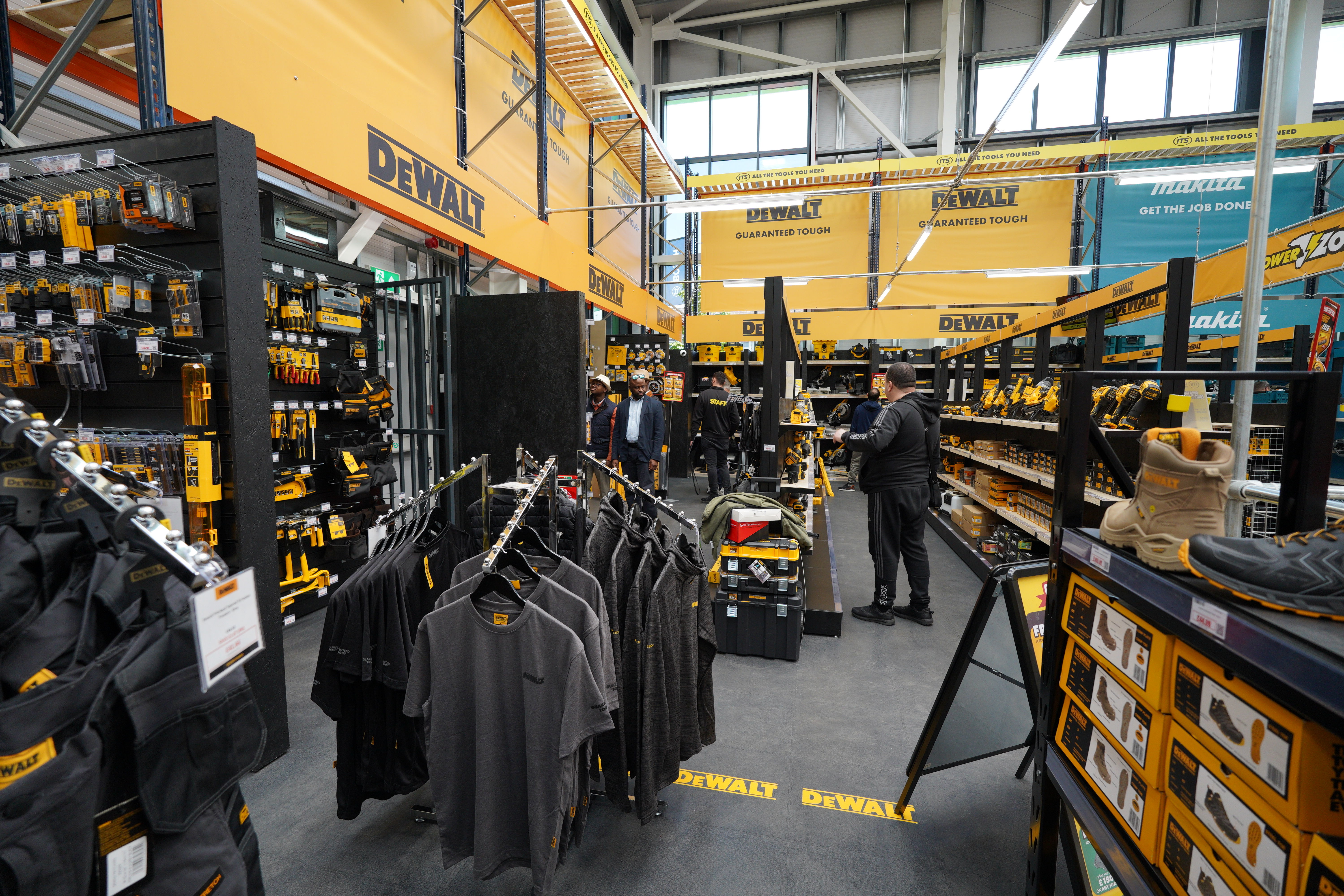 A retail store aisle displaying tools and merchandise on shelves and racks.