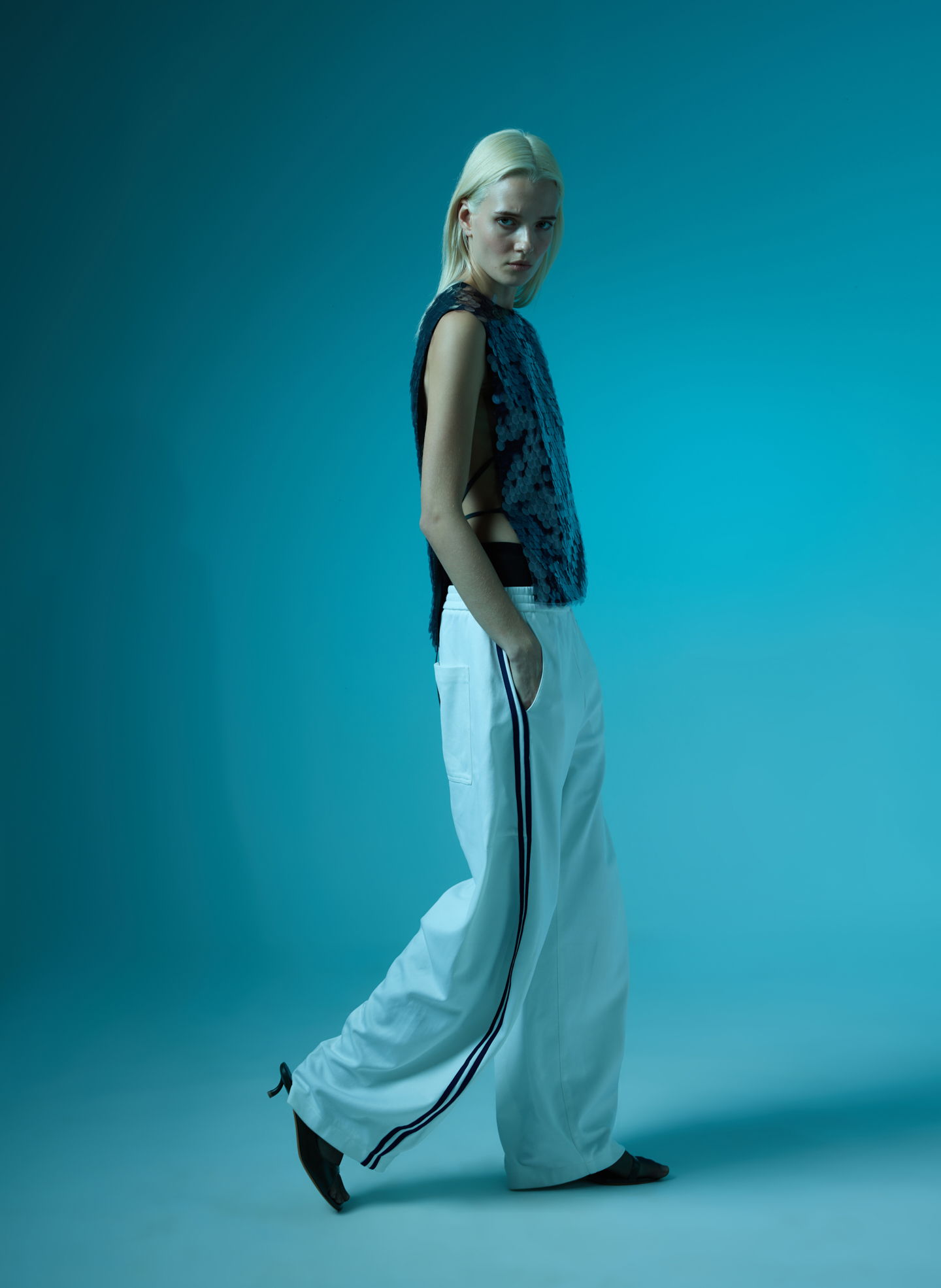 Model wearing casual outfit against a blue background.