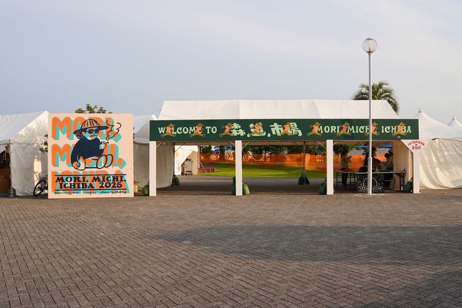 Tents set up for an outdoor event with colorful signage.