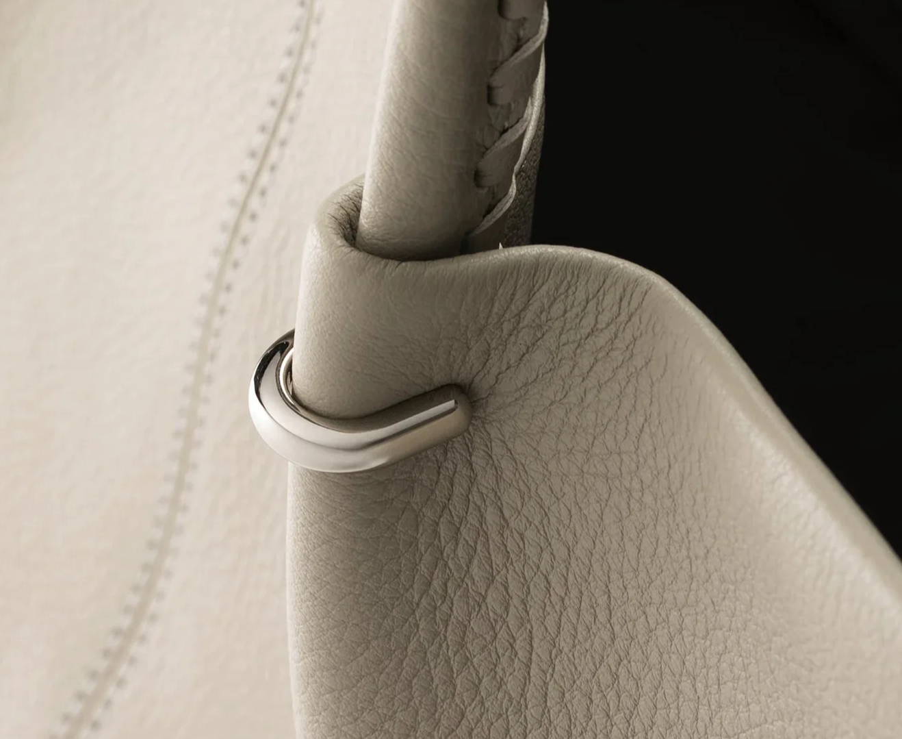Close-up of a beige handbag showing its strap and texture.