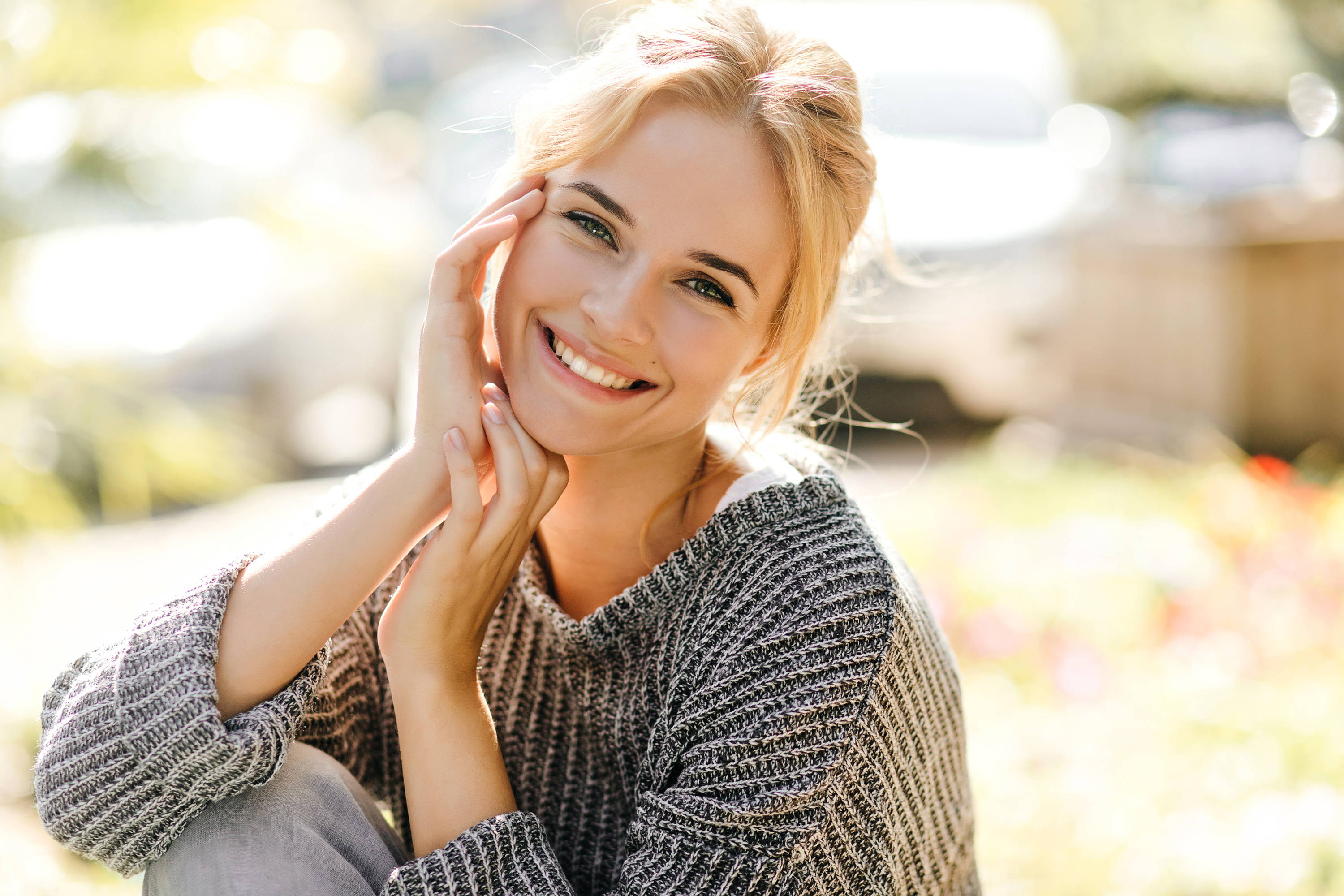 Positive woman with charming smile looks into camera