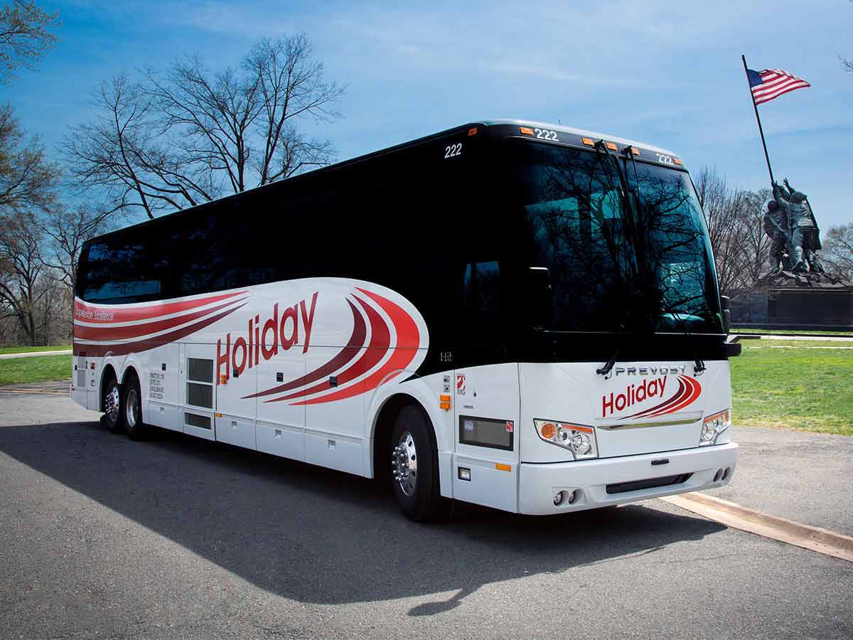 A motorcoach bus, parked outside on a sunny day