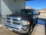 Front-left view of dark Ram pickup in self-service car wash bay with Texas license plate